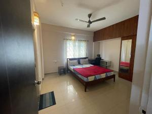 1 dormitorio con 1 cama con manta roja en The Canopy House en Bangalore