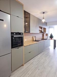 uma cozinha com electrodomésticos em aço inoxidável e pisos em madeira em London Residence - Suceava City - em Suceava