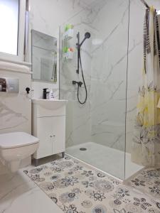 uma casa de banho com um chuveiro, um WC e um lavatório. em London Residence - Suceava City - em Suceava