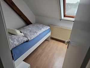 a small bed in a small room with a window at Ferienwohnung Linden 87 in Willich