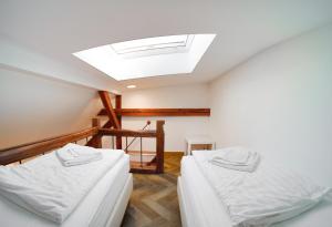 two beds in a room with a skylight at Tóni Villa in Budapest