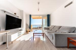 Il comprend un salon doté d'un canapé et d'une télévision à écran plat. dans l'établissement Espectacular Vista Al Mar, à Fuengirola