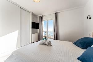 - une chambre avec un grand lit blanc et une fenêtre dans l'établissement Espectacular Vista Al Mar, à Fuengirola