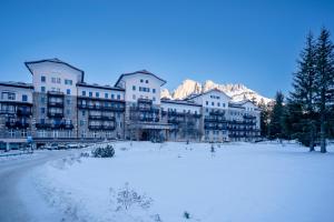 un grupo de edificios con nieve en el suelo en Grand Hotel Carezza Multiproprietà, en Carezza al Lago