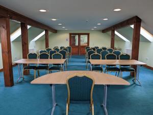 uma sala de conferências com mesas e cadeiras em Lakeside Lodge em Pidley