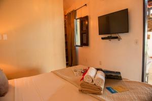 pokój hotelowy z łóżkiem z ręcznikami i telewizorem z płaskim ekranem w obiekcie Pousada Vila Canoa w mieście Canoa Quebrada