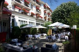 an outdoor patio with tables and chairs and umbrellas at Carlton Lausanne Boutique Hôtel in Lausanne