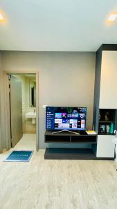 a living room with a large flat screen tv on a wall at The base Central Pattaya 1005 by Numam in Pattaya Central