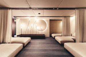 ゲルロスにあるTraumhotel Alpina Superior Yoga Ayurvedahotelのカーテン付きの部屋のベッド1列