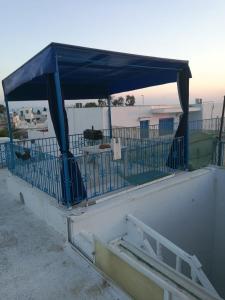 niebieski baldachim na budynku z płotem w obiekcie La maison 4 puits w mieście Sidi Bou Said