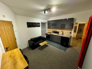 a living room with a couch and a kitchen at Flat 2,Gelli Gaer in Aberystwyth