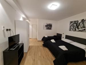 アルゲーロにあるMonti Guest House Algheroのベッドルーム1室(ベッド2台、薄型テレビ付)