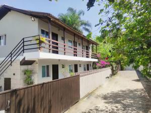 una casa con una valla de madera y una puerta en Residencial Barceloneta, en Florianópolis