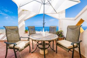 un patio con mesa, sillas y el océano en Panoramic Apartment, en Cumbre del Sol