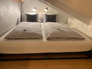 a bed with two pillows on top of it at Chiemgau-LOFT zwischen Seenzauber und Gipfelglück in Riedering