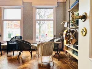 een kamer met stoelen, een tafel en een raam bij 22b&b in Antwerpen