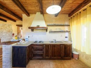una cocina con armarios de madera y fregadero en Casa Barbici, en Rošini