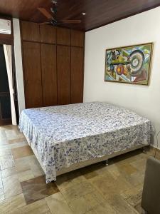 a bedroom with a bed and a painting on the wall at Quinta do Conde in Lauro de Freitas