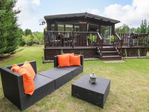 a house with a couch and a table in the grass at Riverside Rest in Builth Wells