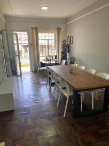 - une salle à manger avec une table et des chaises en bois dans l'établissement Gup Hostel, à Curitiba