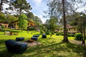 a yard with several couches in the grass at Pousada Serra Villena in Monte Verde