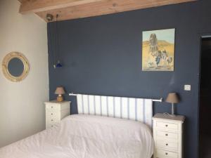 ein blaues Schlafzimmer mit einem Bett und zwei Nachttischen in der Unterkunft Villa en front de mer in Narbonne-Plage