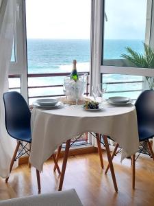 a table with a plate of food on it with a view of the ocean at ALMA DE MALPICA apartamento nuevo en el centro in Malpica