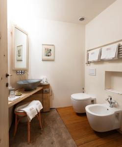 a white bathroom with a sink and a toilet at Antica Corte Pallavicina Relais in Polesine Parmense