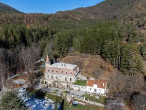 - une vue aérienne sur une grande maison dans les montagnes dans l'établissement Château le Beylon - Chambres d'hôtes, à Montmaur