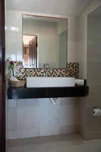 bagno con lavandino bianco e specchio di Pousada Vila Canoa a Canoa Quebrada