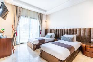 a hotel room with two beds and a large window at One Hotel Casablanca in Casablanca