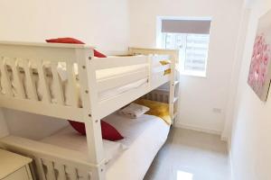 a white bunk bed in a white room at Walnut Flats-F2, 3-Bedroom with Garden & Patio - AC, Parking, Netflix, WIFI - Close to Oxford, Bicester & Blenheim Palace in Oxford