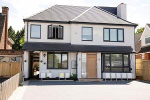 a white house with black windows and a driveway at Walnut Flats-F2, 3-Bedroom with Garden & Patio - AC, Parking, Netflix, WIFI - Close to Oxford, Bicester & Blenheim Palace in Oxford