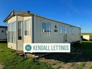 a tiny house with a sign in front of it at Abi in Selsey