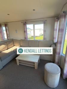 a living room with a couch and a coffee table at Abi in Selsey