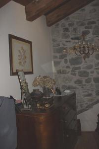 um quarto com uma cómoda de madeira e uma parede de pedra em Eremo Gioioso em Pontremoli