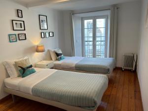 une chambre avec deux lits et une fenêtre dans l'établissement FADO Bairro Alto - SSs Apartments, à Lisbonne