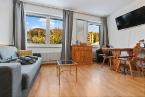 a living room with a couch and a table at Studio cosy au centre de Crans-Montana (1-4 personnes) in Crans-Montana