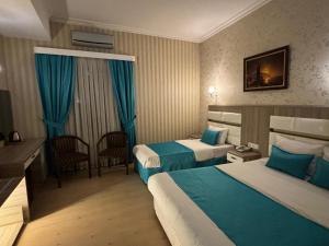 Habitación de hotel con 2 camas y escritorio en Nil Hotel, en Estambul