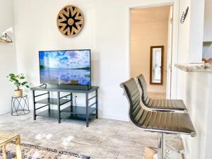 a living room with a tv and a table with a chair at Charming Flat Near The City in San Diego