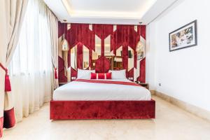 One Hotel Casablanca في الدار البيضاء: غرفة نوم بسرير كبير مع ستائر حمراء