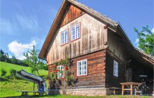 una casa de madera con un tobogán delante de ella en Ferienhaus Bad St, Leonhard, en Bad St. Leonhard im Lavanttal