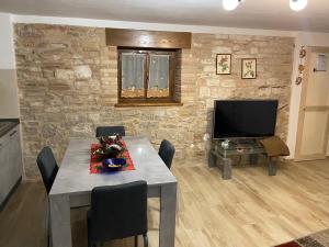 a dining room with a table and a television at Home Sweet Home in Foligno