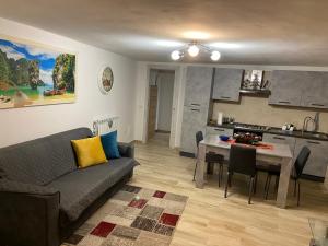 a living room with a couch and a table and a kitchen at Home Sweet Home in Foligno