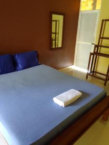 Una cama con una toalla encima. en Serene Inn Kandana en Kandana