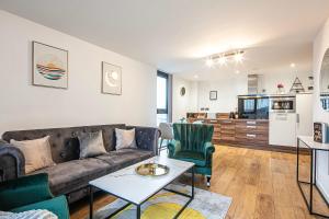 a living room with a couch and a table at Stylish 2 Bed City Centre Apartment with Sofa Bed - FREE Parking, Coffee Machine, Netflix & Alexa in Sheffield