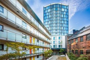 an apartment building with a tall building in the background at Stylish 2 Bed City Centre Apartment with Sofa Bed - FREE Parking, Coffee Machine, Netflix & Alexa in Sheffield