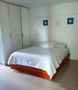 1 dormitorio con 1 cama con sábanas y armarios blancos en The Warren @Torreavila en Caracas