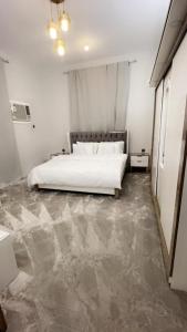 una camera con letto bianco e pavimento in marmo di شقة مميزه a Muhayil