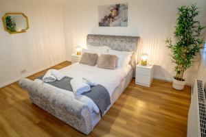 Deluxe 2 Bed Apartment- Near Heathrow, Legoland, Windsor Slough في سلاو: غرفة نوم بسرير ابيض كبير ومصباحين